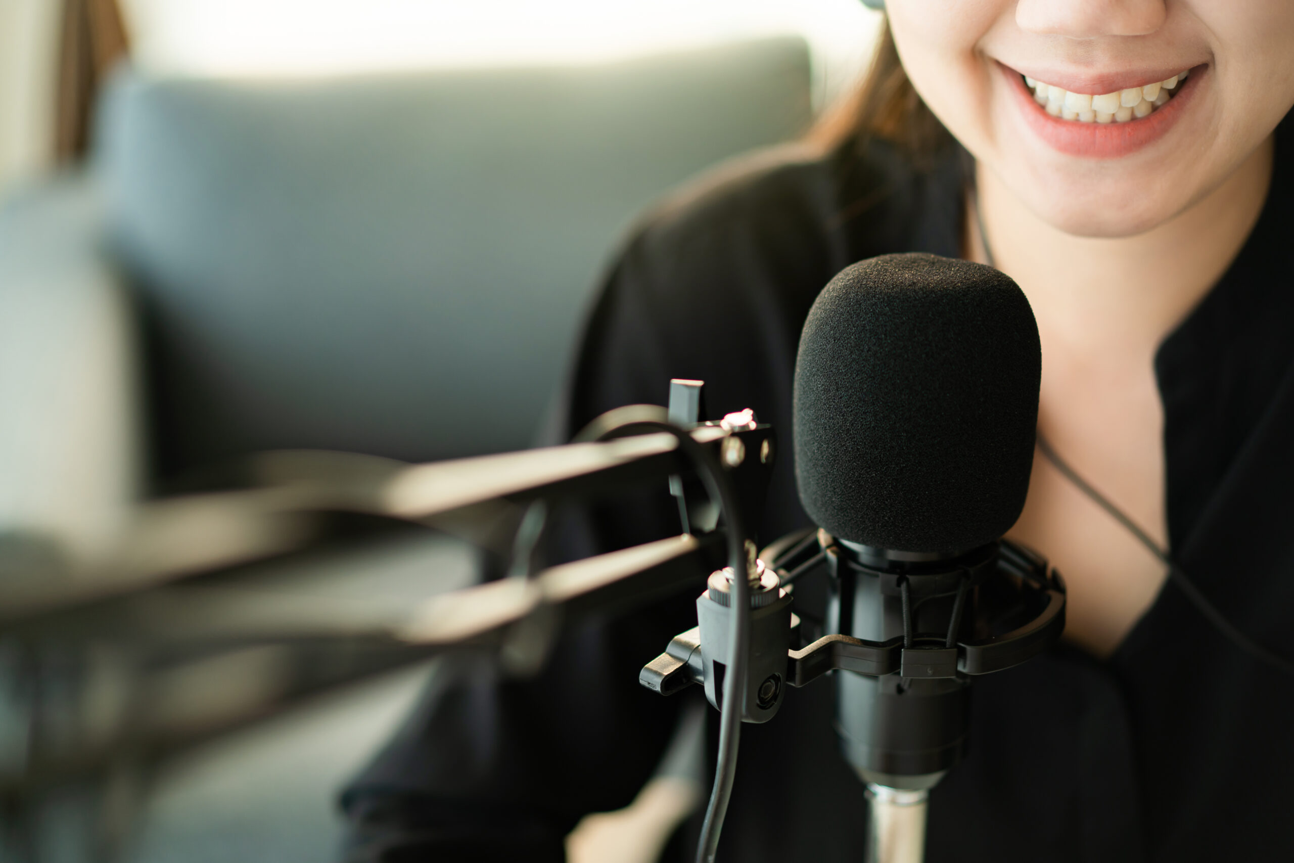 Young Asian woman recording a podcast in a living room